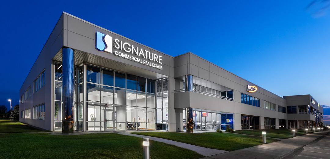 Signature Real Estate Building at night time.